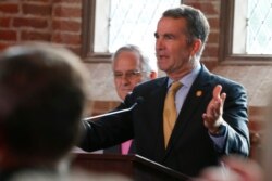 Virginia Gov. Ralph Northam addresses a meeting of the Virginia General Assembly on the 400th anniversary of the first House of Burgess meeting at a church in Historic Jamestown, Va., on the site where the meeting took place, July 30, 2019.