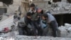 Syrians rescue a child following a reported government airstrike in the rebel-held town of Hamouria, in the besieged Eastern Ghouta region on the outskirts of the capital Damascus, Feb. 21, 2018. 
