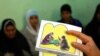 FILE - A counselor holds up cards used to educate women about female genital mutilation (FGM).