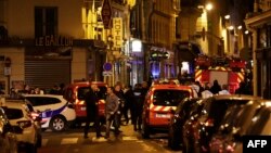 Policemen and emergency service members stand in a blocked street in Paris after one person was killed and several injured by a man armed with a knife, who was shot dead by police, May 12, 2018.