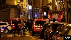 Policemen and emergency service members stand in a blocked street in Paris after one person was killed and several injured by a man armed with a knife, who was shot dead by police, May 12, 2018.