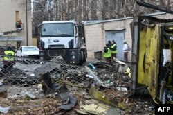 Trabajadores comunales limpian escombros en el patio de un edificio residencial dañado luego de un ataque con misiles en Járkov el 25 de noviembre de 2024.