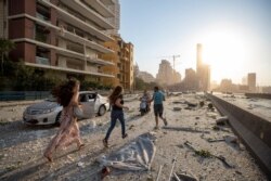 Personas huyen de lugar de una masiva explosión en el puerto de Beirut, Líbano, que dejó al menos 70 muertos y miles de heridos. Agosto 4 de 2020.