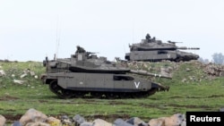 FILE - Israeli soldiers take part in an exercise in the Israeli-occupied Golan Heights, near the ceasefire line between Israel and Syria.