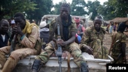 FILE - Seleka fighters sit on a pick-up truck in the town of Goya, Central African Republic, June 11, 2014. UPC rebels, a Seleka offshoot, are being blamed for the current surge in violence in Basse-Kotto, a prefecture in the eastern part of the CAR.