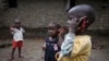Olematu, 3 (left), and Ibrahim, 4, talk on toy phones in a village near Kenema, Sierra Leone. Their 15-year-old sister, Betty, has taken charge after their mother’s death from Ebola. Betty survived an Ebola infection. (© UNICEF / Bindra) 
