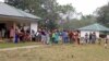 FILE - A still image taken from a video shot on Dec. 9, 2017, shows Cameroonian refugees standing outside a center in Agbokim Waterfalls village, Nigeria, near the country's border with Cameroon.