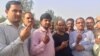 Voters emerge from a polling station in Western Uttar Pradesh holding up their fingers which get marked with ink after they cast ballots. 