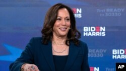 ARCHIVO - La compañera de fórmula del candidato demócrata a la presidencia, exvicepresidente Joe Biden, senadora Kamala Harris, demócrata por California, firma los documentos para recibir la nominación demócrata para presidente y vicepresidente de EE.UU.