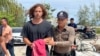 A Thai police officer escorts Daniel Sancho Bronchalo to Koh Samui Provincial Court in Samui, Thailand, on Aug. 7, 2023. The court on Aug. 29 found Sancho guilty of premeditated murder and sentenced him to life in prison.