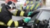 A Czech special police officer, with a protective mask, checks the temperature of a driver during sanitary checks at the border crossing between Germany and Czech Republic, in a measure to protect against the spread of the coronavirus, March 9, 2020.