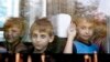 FILE - Children who have fled the fighting in eastern regions of Ukraine look out from a minibus upon their arrival at a railway station, before leaving for their temporary accommodation, in Stavropol, southern Russia, Aug. 21, 2014. 