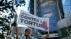 Un manifestante sostiene un cartel que dice "Juntos contra la tortura" afuera de la sede del Servicio Penitenciario durante una protesta de personas con familiares detenidos a quienes llaman presos políticos, el viernes 18 de octubre de 2024. 