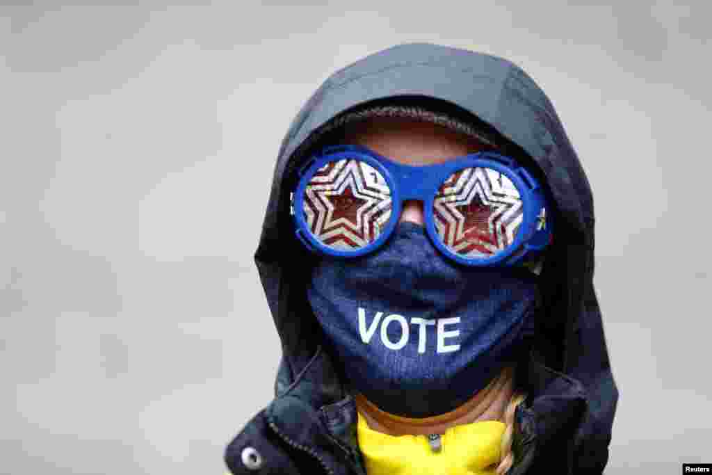 Cesia Kearns con gafas y una máscara facial se ve fuera de un lugar de votación en el CenturyLink Field Event Center el día de las elecciones, en Seattle, Washington.