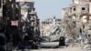 FILE - A fighter of the Syrian Democratic Forces stands amid the ruins of buildings near Clock Square in Raqqa, Syria, Oct. 18, 2017.