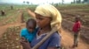 FILE - A woman and her child, who fled from rebel attacks, stand in a field, in Tshikapa, Kasai region, Democratic Republic of Congo, July 27, 2017.