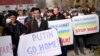 Demonstrators hold placards reading "Putin go home !" and "Help Ukraine! Stop war !" during an anti-war rally in front of the Russian embassy in Kyiv, March 7, 2014. 