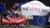 Brexit supporters and opponents with signs and flags are seen outside the Houses of Parliament in London, Britain, March 12, 2019.