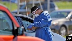 FILE - A health care worker gathers information from a person wishing to get a coronavirus test, May 5, 2020, in Sarasota, Fla. The United Nations has begun an initiative to counter the spread of online misinformation related to the coronavirus pandemic.
