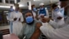A student receives a COVID-19 vaccine from a health worker at a vaccination center at Jamia Naeemia, an Islamic university in Lahore, Pakistan, July 12, 2021.