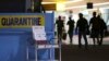 Passengers walk past the medical quarantine area showing information sheets for the Middle East respiratory syndrome coronavirus at the arrival section of Manila's International Airport in Paranaque, south of Manila, April 16, 2014.