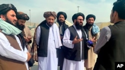 Funcionarios talibanes son entrevistados por periodistas dentro del Aeropuerto Internacional Hamid Karzai después de la retirada de Estados Unidos en Kabul, Afganistán, el 31 de agosto de 2021.