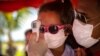 A little girl wearing a face mask amid the new coronavirus pandemic gets her temperature taken at a police checkpoint, at the entrance to the province of Havana, Cuba, Monday, Aug. 10, 2020. Cuban authorities on Monday re-imposed measures aimed at…