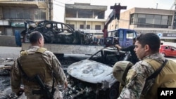 Soldados libaneses hacen guardia mientras una grúa retira los restos de un vehículo en el lugar de un ataque con aviones no tripulados israelíes en Aaraiya, al este de Beirut, el 7 de noviembre de 2024, en medio de la guerra en curso entre Israel y Hezbolá.