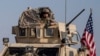 FILE - A U.S. military convoy drives near the town of Qamishli, northern Syria, Oct. 26. 2019. Two recent raids by a U.S.-led coalition in the oil-rich Deir el-Zour area were highlighted by the capture of a midlevel Islamic State leader.