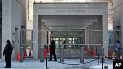 Un agente de seguridad camina frente a la entrada de la oficina central de la Agencia de Alcohol, Tabaco, Armas de Fuego y Explosivos de Estados Unidos, el 23 de enero de 2014, en Washington. 