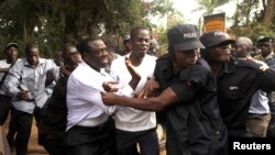 FILE - Ugandan policemen arrest opposition leader Kizza Besigye (front L) ahead of a rally to demonstrate against corruption and economic hardships in Uganda's capital Kampala, Jan. 19, 2012. 