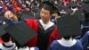 A man adjusts a student's mortar board during the graduation ceremony at Fudan University in Shanghai, June 28, 2006. (File)