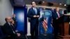 President Donald Trump listens as Treasury Secretary Steven Mnuchin speaks at a news conference in the James Brady Press Briefing Room at the White House, Aug. 10, 2020, in Washington.