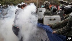 Supporters of opposition presidential candidate Salvador Nasralla struggle with military police for possession of a giant Honduran flag at the Policarpo Paz Garcia neighborhood of Tegucigalpa, Jan. 20, 2018.