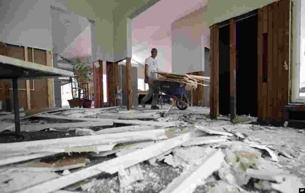José Martínez, remueve los restos de una pared derribada en una casa dañada por las inundaciones de la tormenta tropical Harvey, en Houston, Texas. Foto AP.