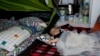 FILE - Yaldof Natzafi, a 1 year -old Afghan baby girl, sleeps at a make shift tent at the west terminal of an abandoned old airport which is used as a shelter for thousands of migrants, in southern Athens, Monday, June 20, 2016. 