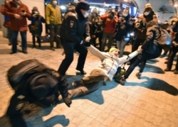 Police officers detain a man at Moscow's Vnukovo airport where Russian opposition leader Alexei Navalny is expected to arrive, outside Moscow, Russia, Jan. 17, 2021.