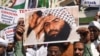 Indian Muslims hold a scratched photo of Jaish-e-Mohammad group chief, Maulana Masood Azhar, as they shout slogans against Pakistan during a protest in Mumbai on February 15, 2019, the day after an attack on a paramilitary Central Reserve Police Force (CR