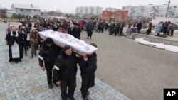 Funerales de una de las víctimas del bombardeo del sábado en Mariupol, Ucrania.