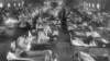 FILE - Influenza victims crowd into an emergency hospital near Fort Riley, Kansas in 1918, when the Spanish flu pandemic killed at least 20 million people worldwide.