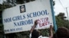 An activist puts a message on the sign board at the main entrance of Moi Girls School Nairobi, a prestigious government boarding school in Nairobi, Kenya, June 4, 2018, during a protest against alleged rape of three girls at the school.