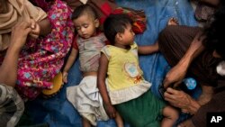 FILE - Two children sleep as Rohingya Muslims who have fled persecution in Myanmar wait along the border for permission to move further towards refugee camps near Palong Khali, Bangladesh, Nov. 2, 2017.