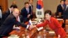 South Korean President Park Geun-hye (R) shakes hands with Russian President Vladimir Putin (L) during their meeting at the presidential Blue House in Seoul, Nov. 13, 2013.