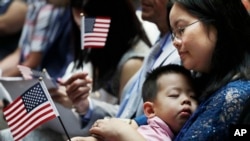 ARCHIVO - Una inmigrante de China sostiene a su hijo de tres años y una bandera de Estados Unidos durante una ceremonia de naturalización en la Biblioteca Pública de Nueva York, en la ciudad de Nueva York, el 3 de julio de 2018. 
