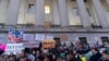 People listen to speakers during a rally against Elon Musk outside the U.S. Treasury Department in Washington, Feb. 4, 2025. 