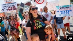 Demonstrators chant as they protest the arrival of President Donald Trump outside Miami Valley Hospital after a mass shooting that occurred in the Oregon District early Sunday morning, Aug. 7, 2019, in Dayton, Ohio.