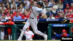Luis Arráez, pelotero venezolano de los Marlins de Miami, batea un triple contra los Filis de Filadelfia el 11 de abril de 2023.