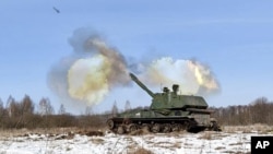 En esta foto tomada de un video proporcionado por el Servicio de Prensa del Ministerio de Defensa de Rusia el martes 15 de febrero de 2022, una montura de artillería autopropulsada dispara en el campo de entrenamiento de Osipovichi durante los ejercicios militares en Belarús.