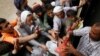 FILE - People gather to collect food rations at a food distribution center in Sana'a, Yemen, March 21, 2017.