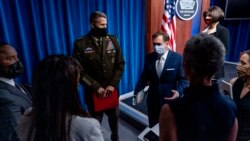 El portavoz del Pentágono, John Kirby, centro derecha, habla con los reporteros al salir de una sesión informativa en el Pentágono en Washington, el miércoles 25 de agosto de 2021.